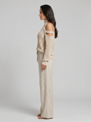Conjunto de top de cuello tortuga en punto beige con hombros al descubierto y pantalones de pierna ancha